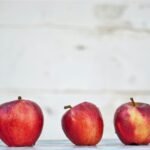 five red apples on white surface